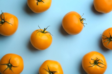 Photo of Yellow tomatoes on light blue background, flat lay