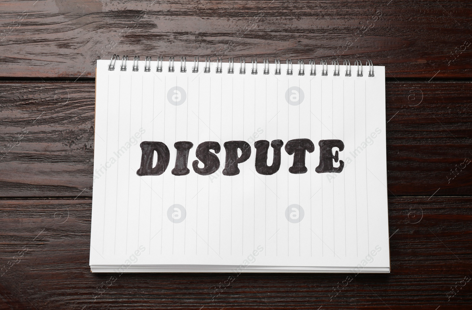 Photo of Notebook with word Dispute on wooden table, top view