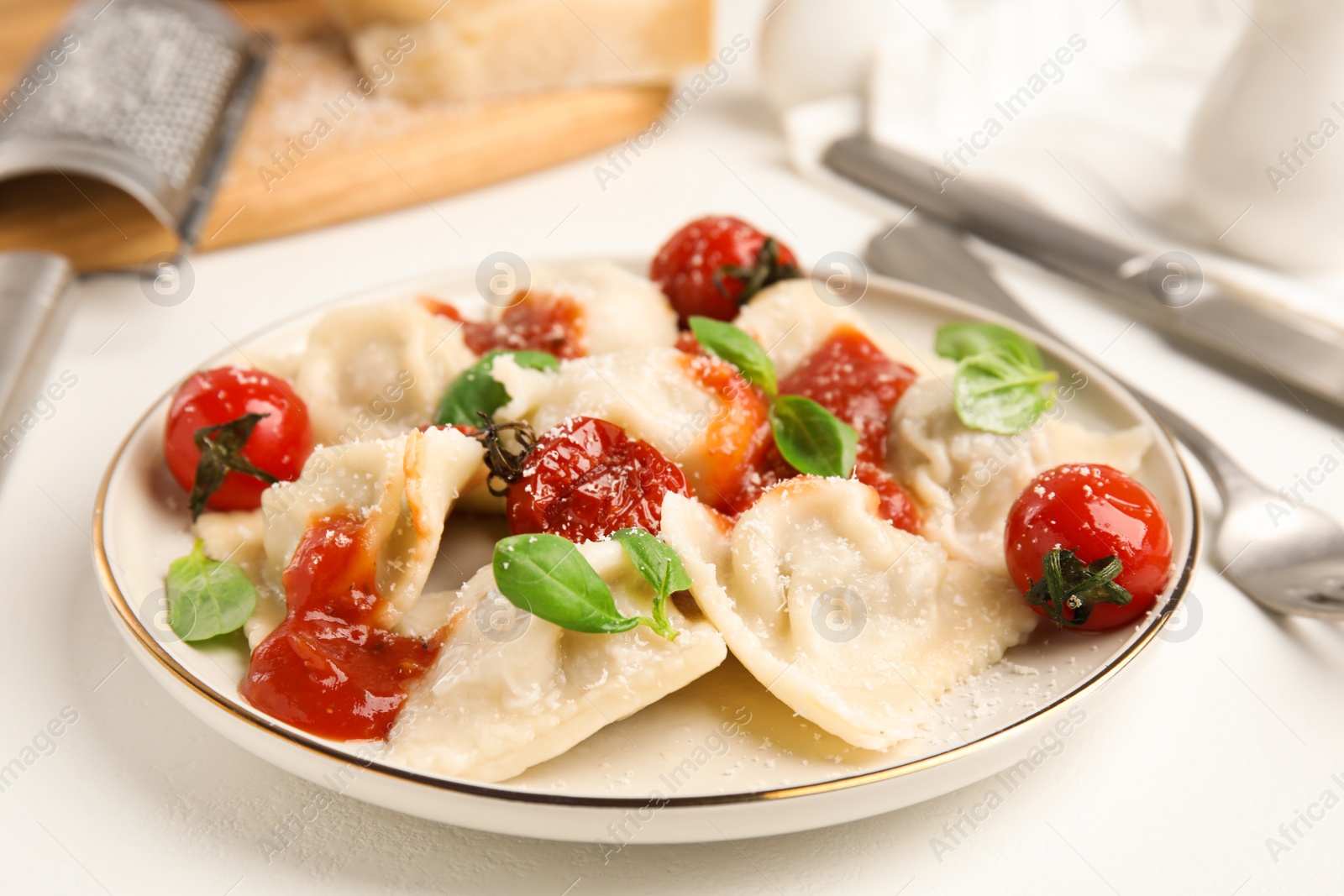 Photo of Tasty ravioli with tomato sauce served on white table