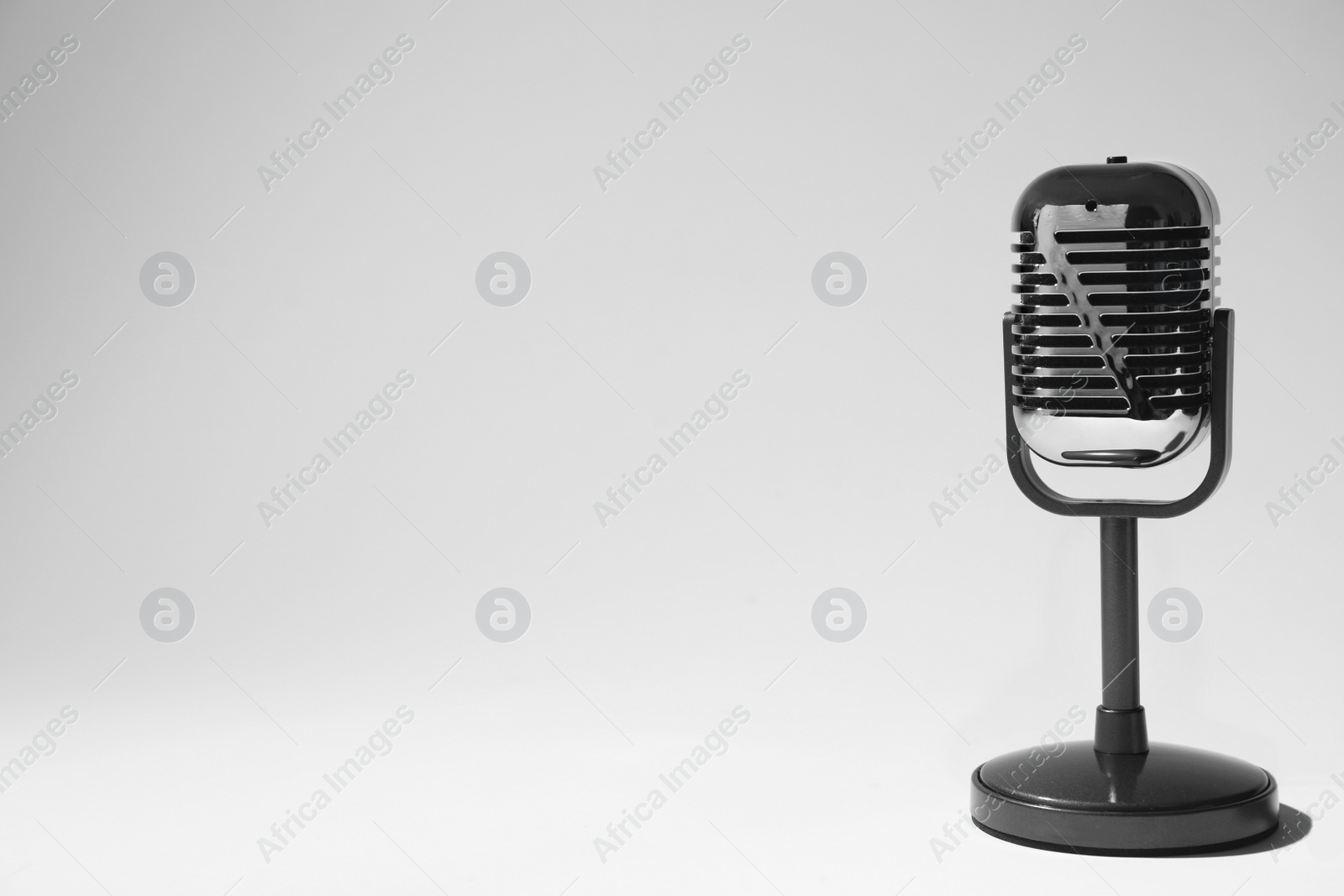 Photo of Retro microphone on light background. Space for text