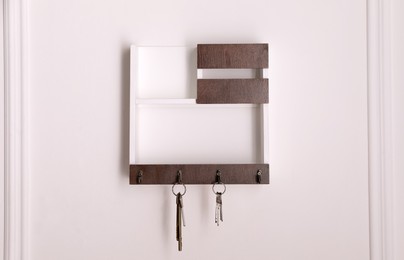 Photo of Wooden hanger for keys on white wall