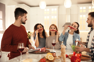 Photo of Happy people having fun while cooking food in kitchen