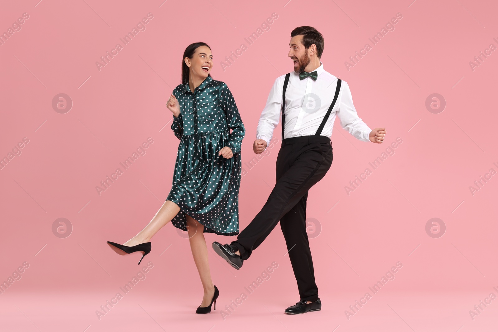 Photo of Happy couple dancing together on pink background