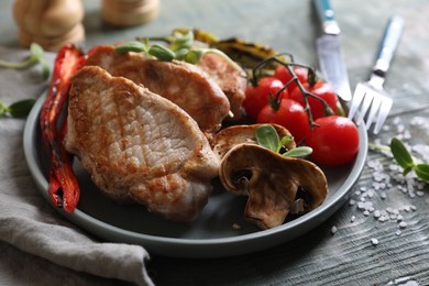 Photo of Delicious grilled meat and vegetables served on wooden table, closeup