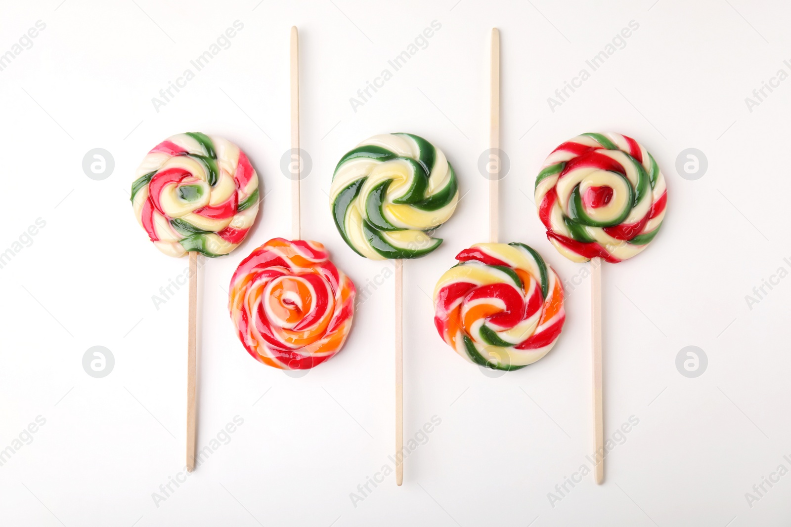 Photo of Many colorful lollipops on white background, flat lay