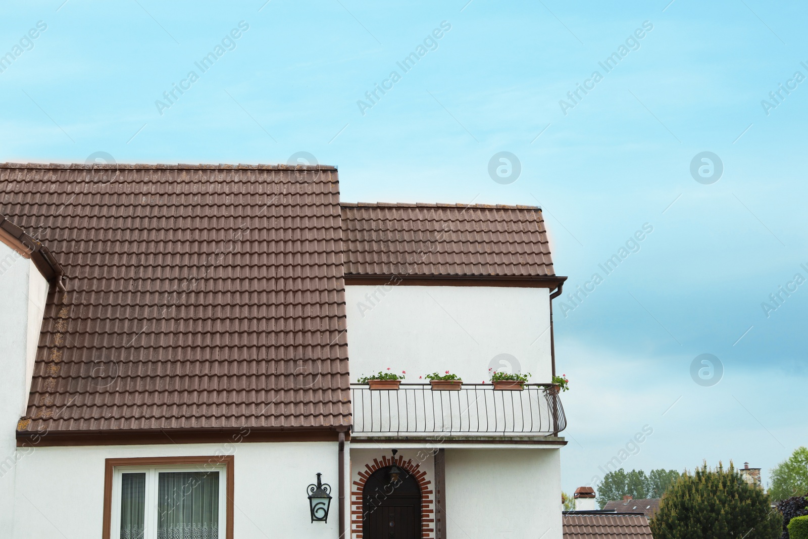 Photo of Beautiful house with brown roof against blue sky