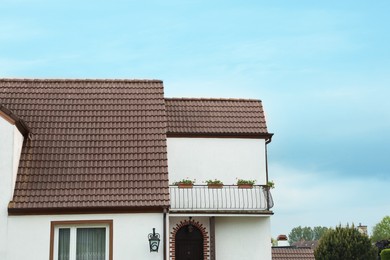 Photo of Beautiful house with brown roof against blue sky