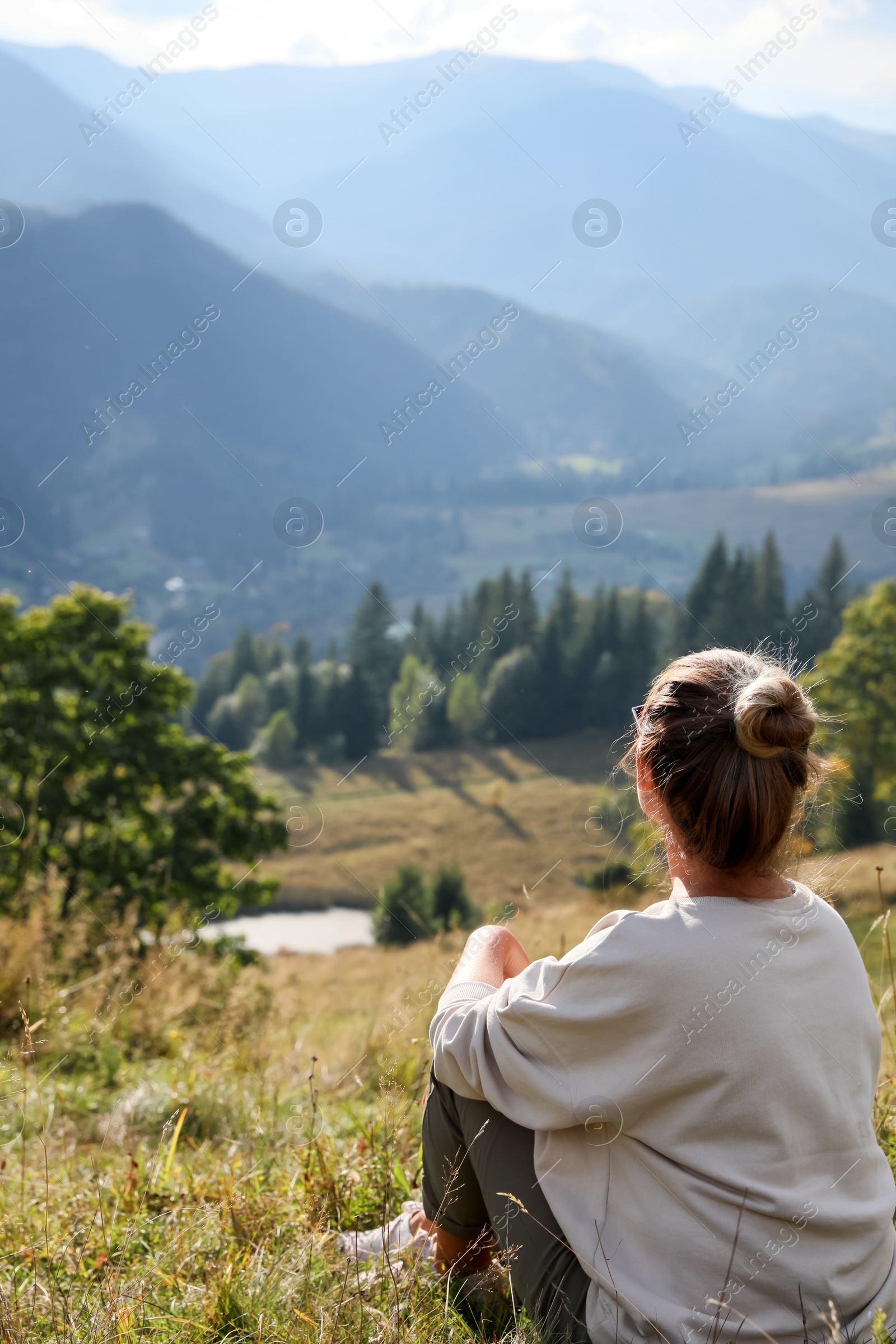 Photo of Woman enjoying beautiful mountain landscape, back view. Space for text