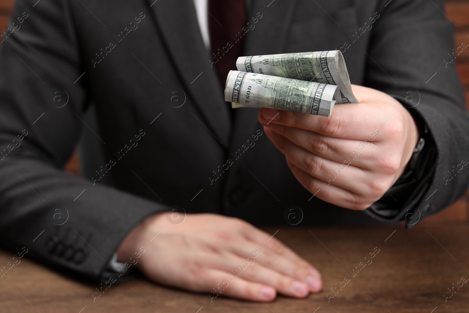 Photo of Man holding money at wooden table, closeup. Currency exchange