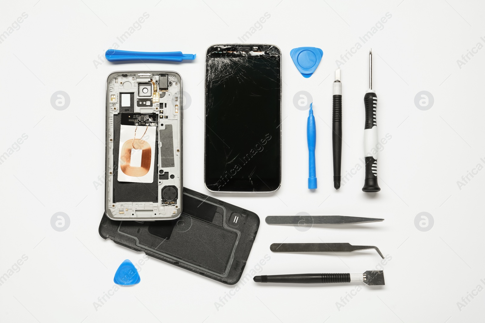 Photo of Damaged smartphone and repair tool set on white background, flat lay