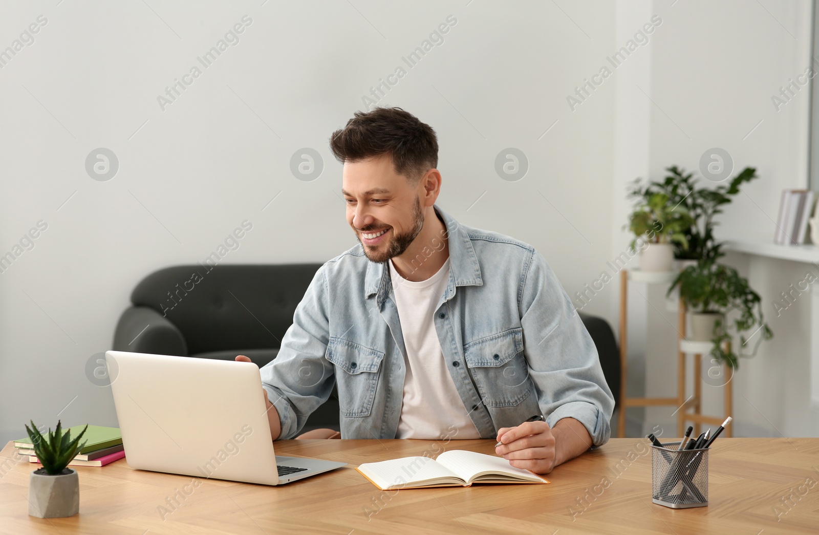 Photo of Man studying on laptop at home. Online translation course