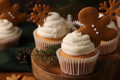 Photo of Different beautiful Christmas cupcakes and fir branches on wooden table. Space for text
