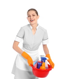 Young chambermaid holding basin with cleaning supplies on white background