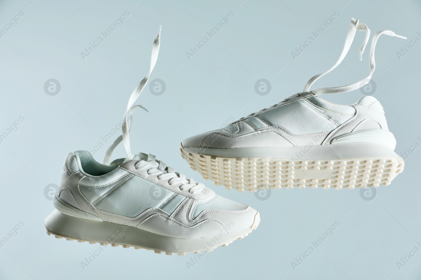 Photo of Pair of stylish white sneakers on light grey background