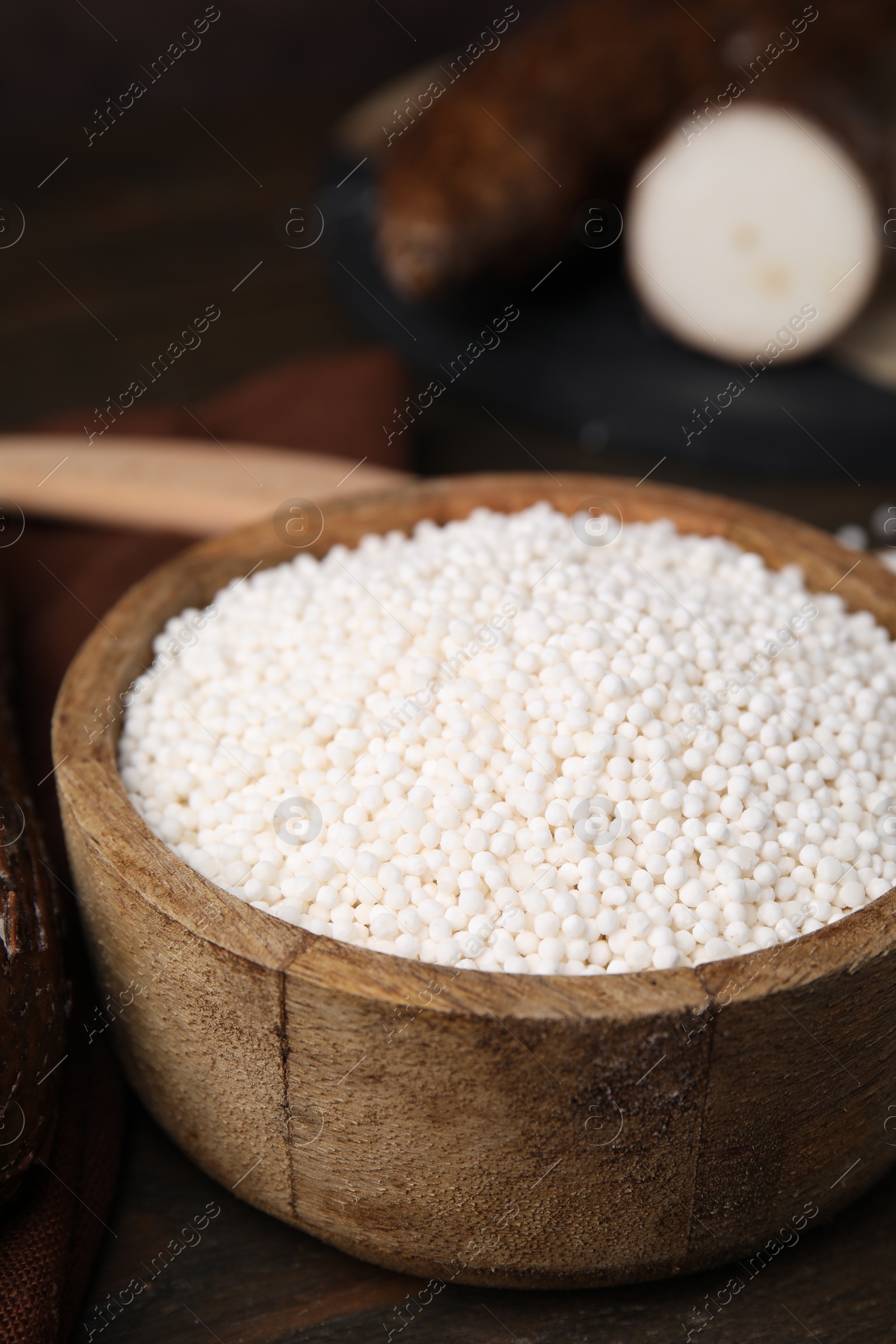 Photo of Tapioca pearls in bowl on wooden table, closeup