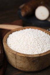 Tapioca pearls in bowl on wooden table, closeup