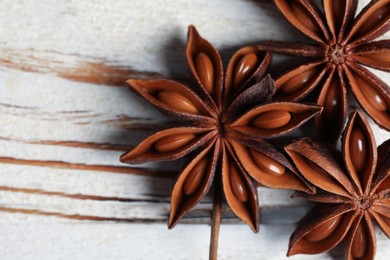 Aromatic anise stars on white wooden table, closeup