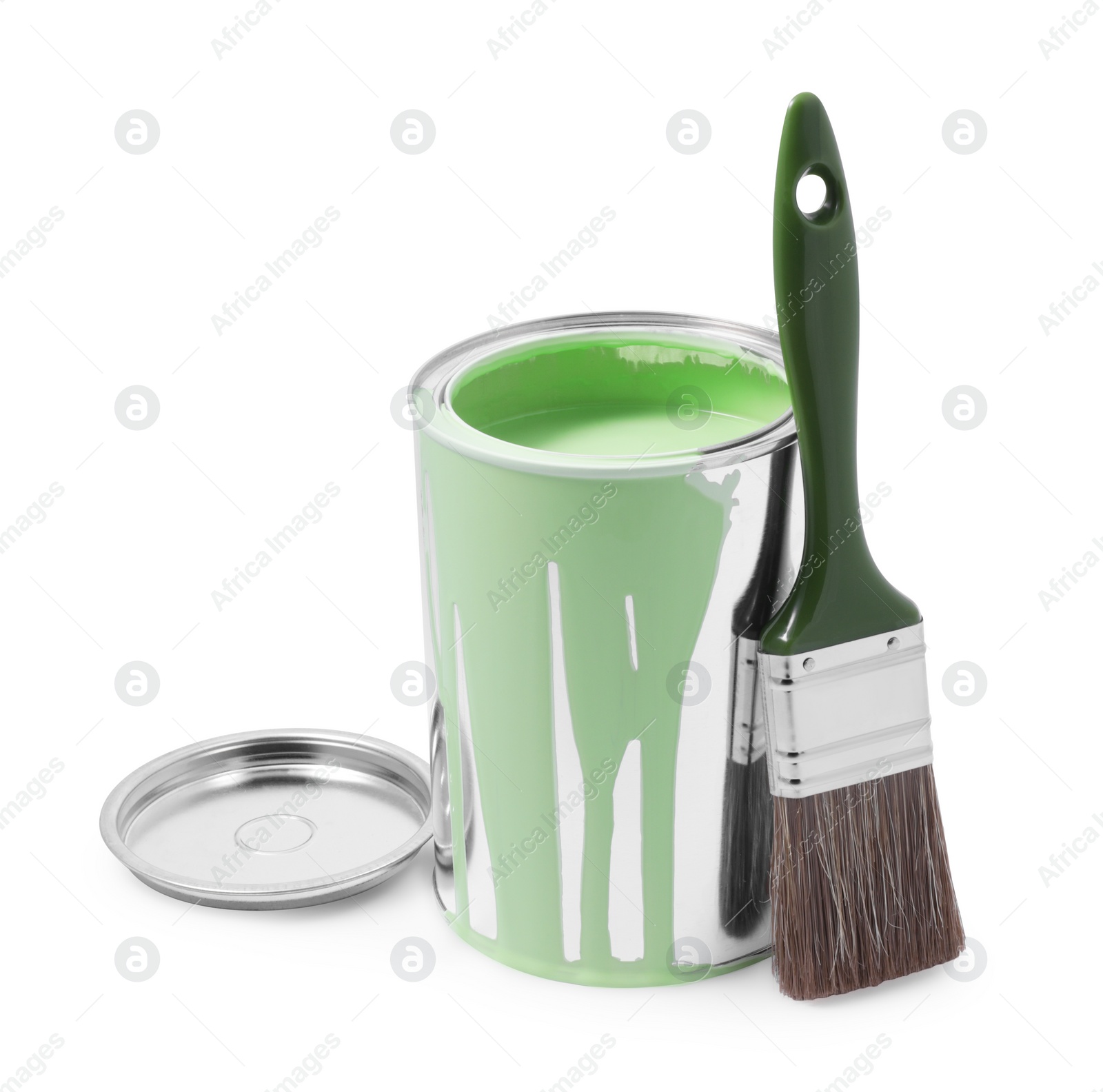 Photo of Can of light green paint and brush isolated on white