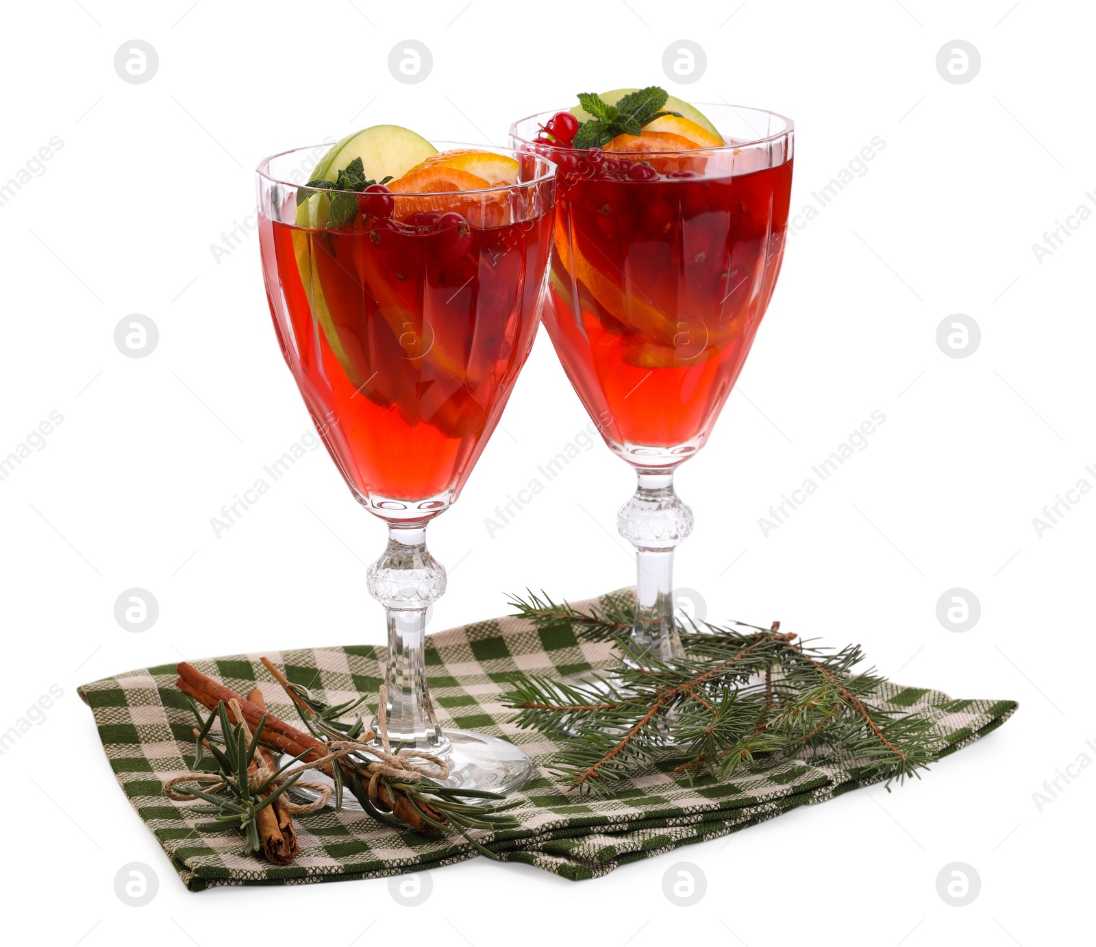 Photo of Christmas Sangria cocktail in glasses, cinnamon and fir tree branch isolated on white