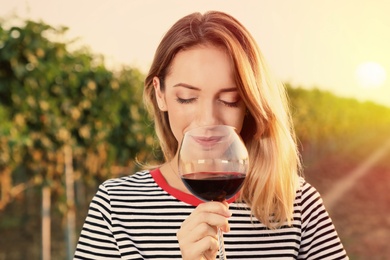 Photo of Young beautiful woman enjoying wine at vineyard on sunny day