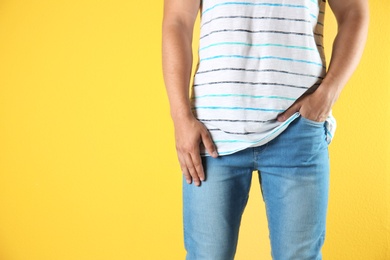 Photo of Young man in stylish jeans on color background