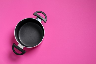 Photo of Empty pot on dark pink background, top view. Space for text