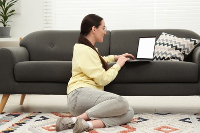 Photo of Woman using laptop on couch at home