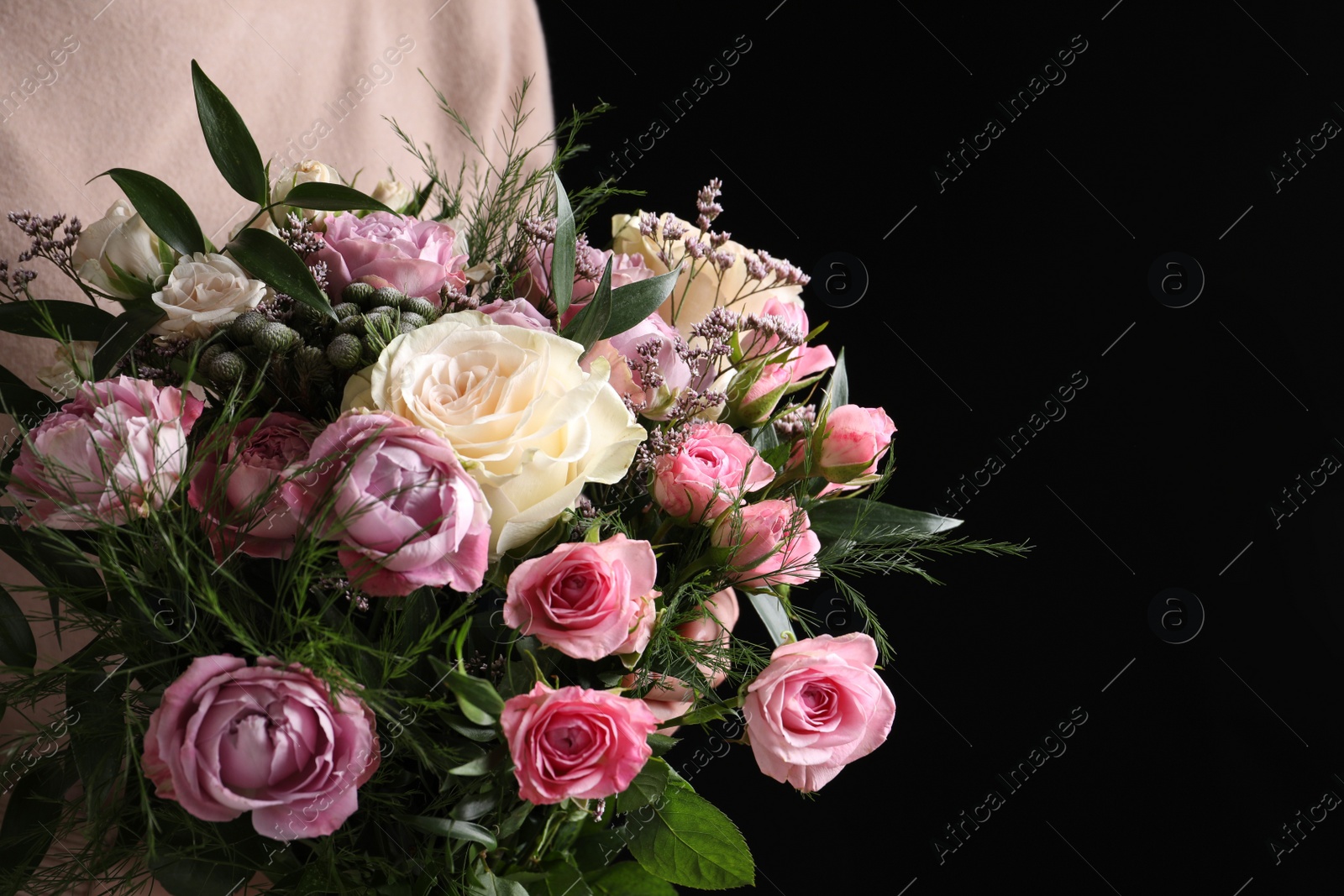 Photo of Woman with bouquet of beautiful roses on black background, closeup