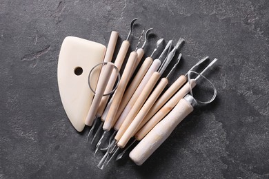 Set of different clay crafting tools on grey table, top view