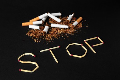 Photo of Word Stop made of matches and broken cigarettes on black background. Quitting smoking concept