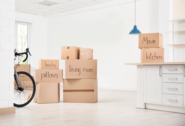 Photo of Cardboard boxes and bicycle indoors. Moving day