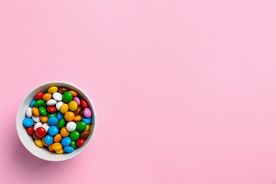 Photo of Delicious bright glazed candies on pink background, top view. Space for text
