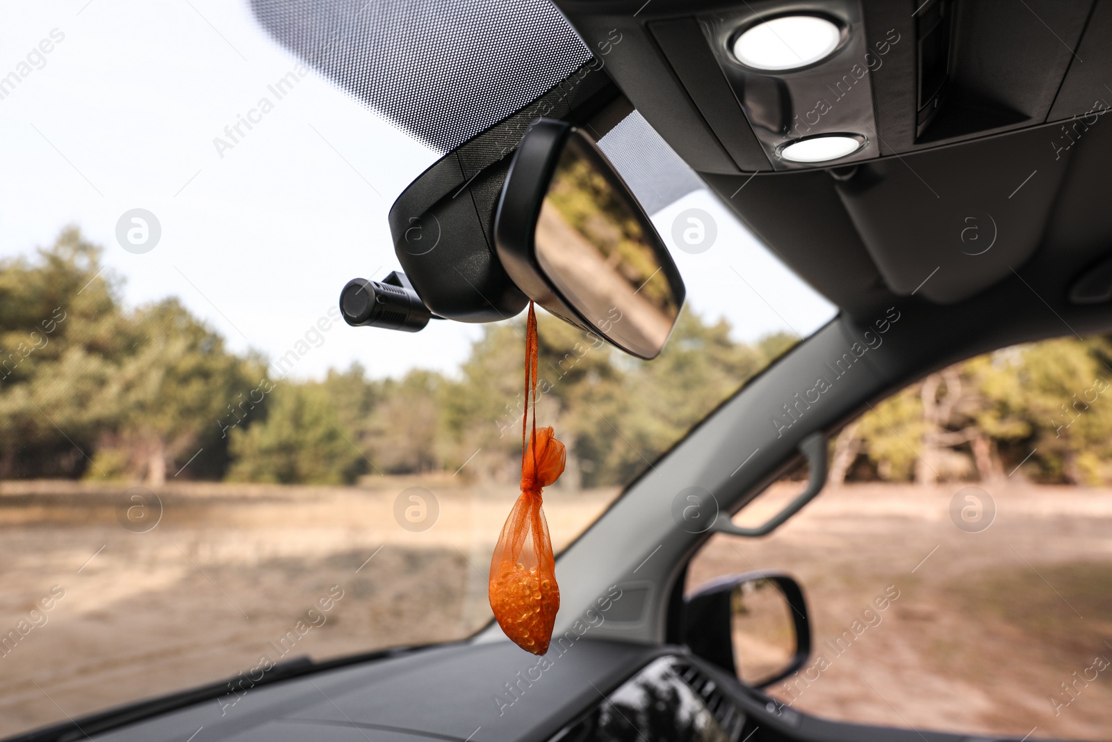 Photo of Air freshener hanging on rear view mirror in car