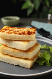 Photo of Delicious turnip cake with lettuce salad served on grey plate, closeup