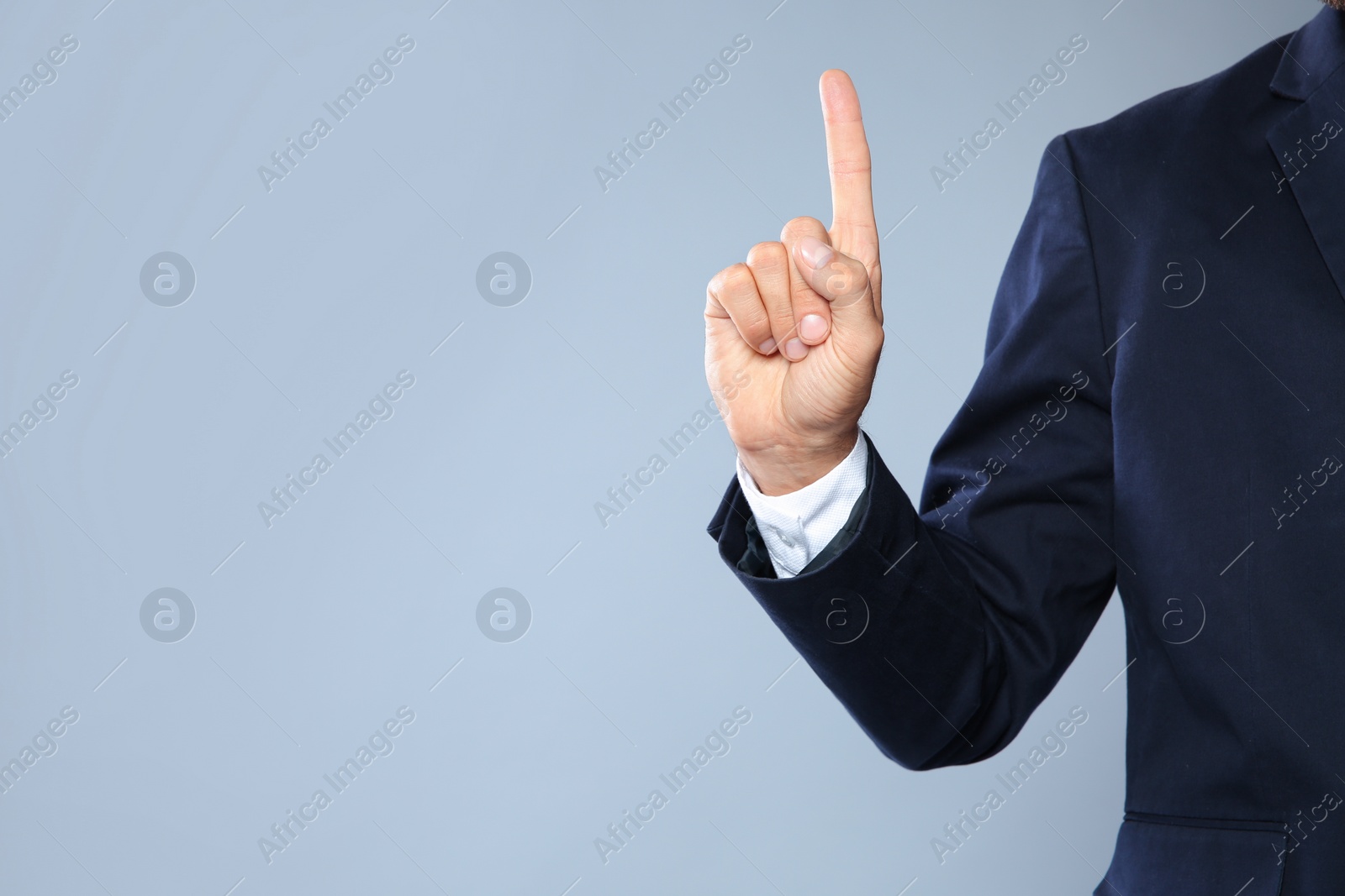 Photo of Businessman pointing on grey background, closeup view of hand with space for text