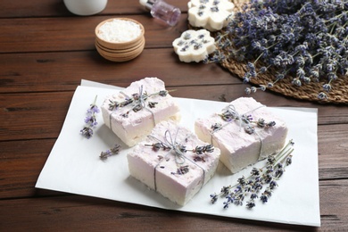 Hand made soap bars with lavender flowers on wooden table