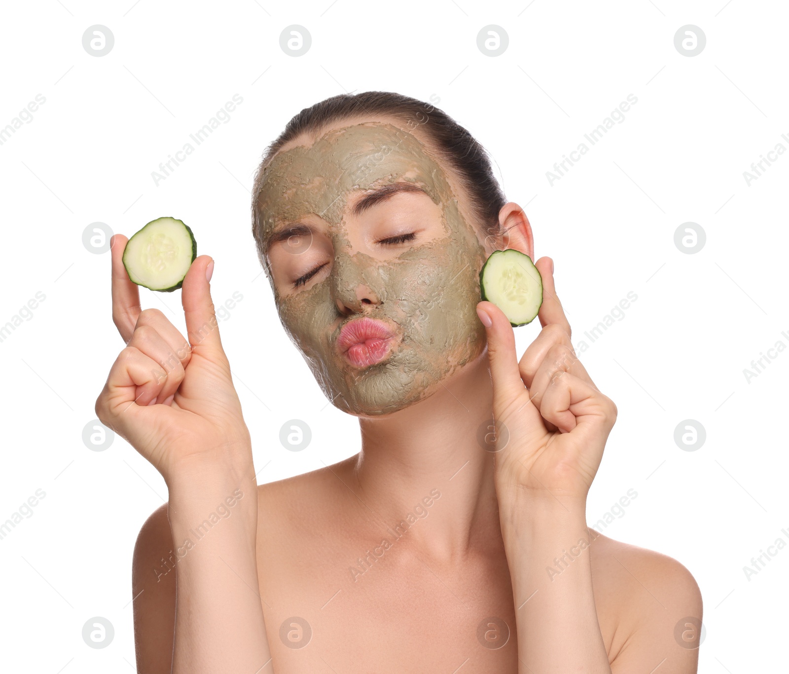Photo of Beautiful woman with clay mask holding pieces of cucumber and blowing kiss on white background