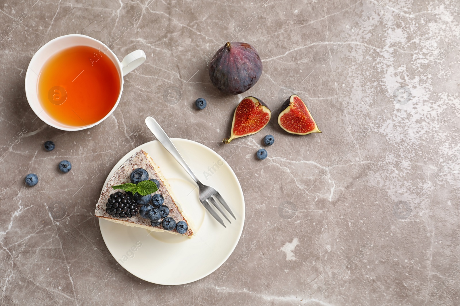 Photo of Flat lay composition with piece of delicious cake on table and space for text. Homemade pastry with fresh berries