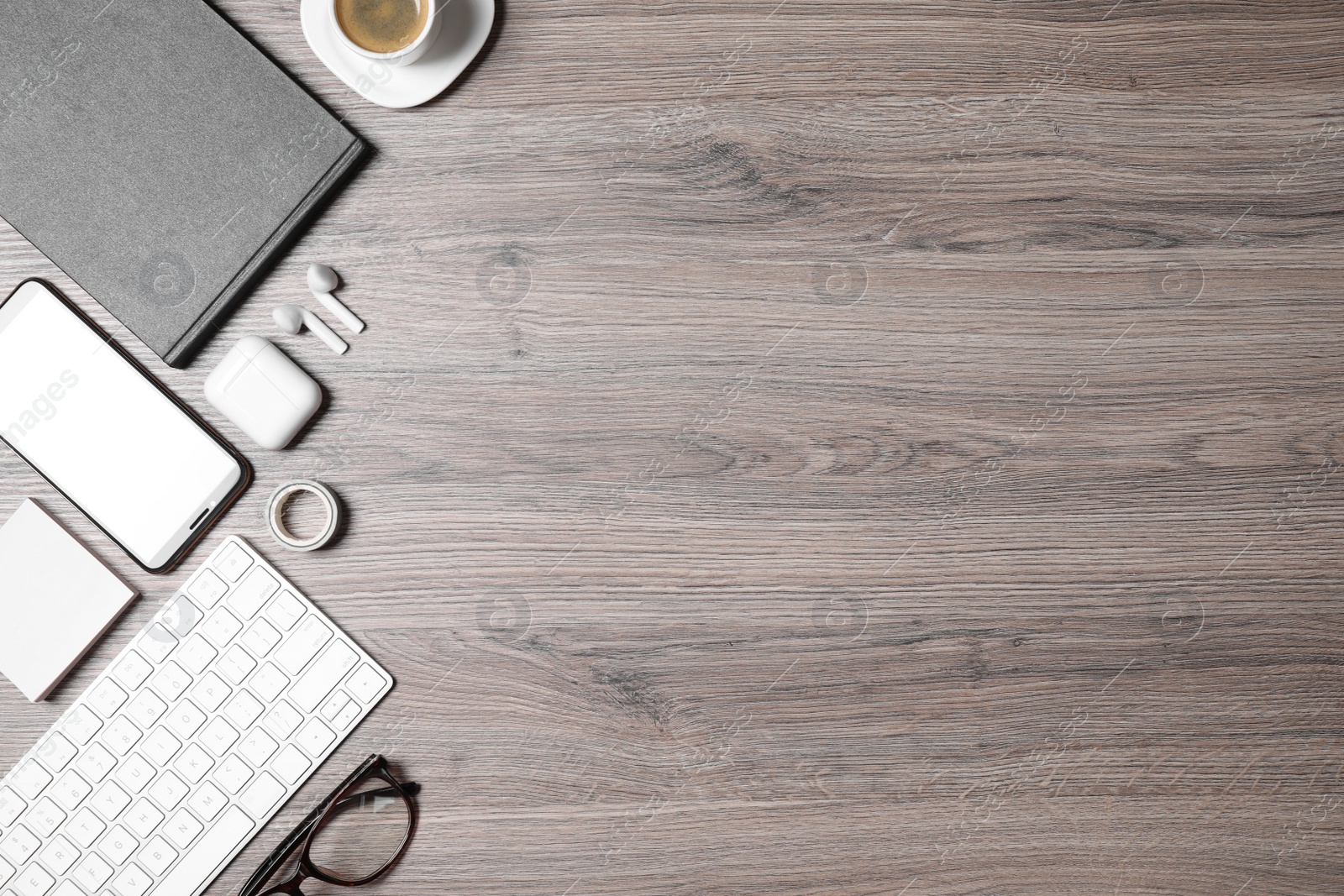 Photo of Flat lay composition with computer keyboard and smartphone on wooden table. Space for text