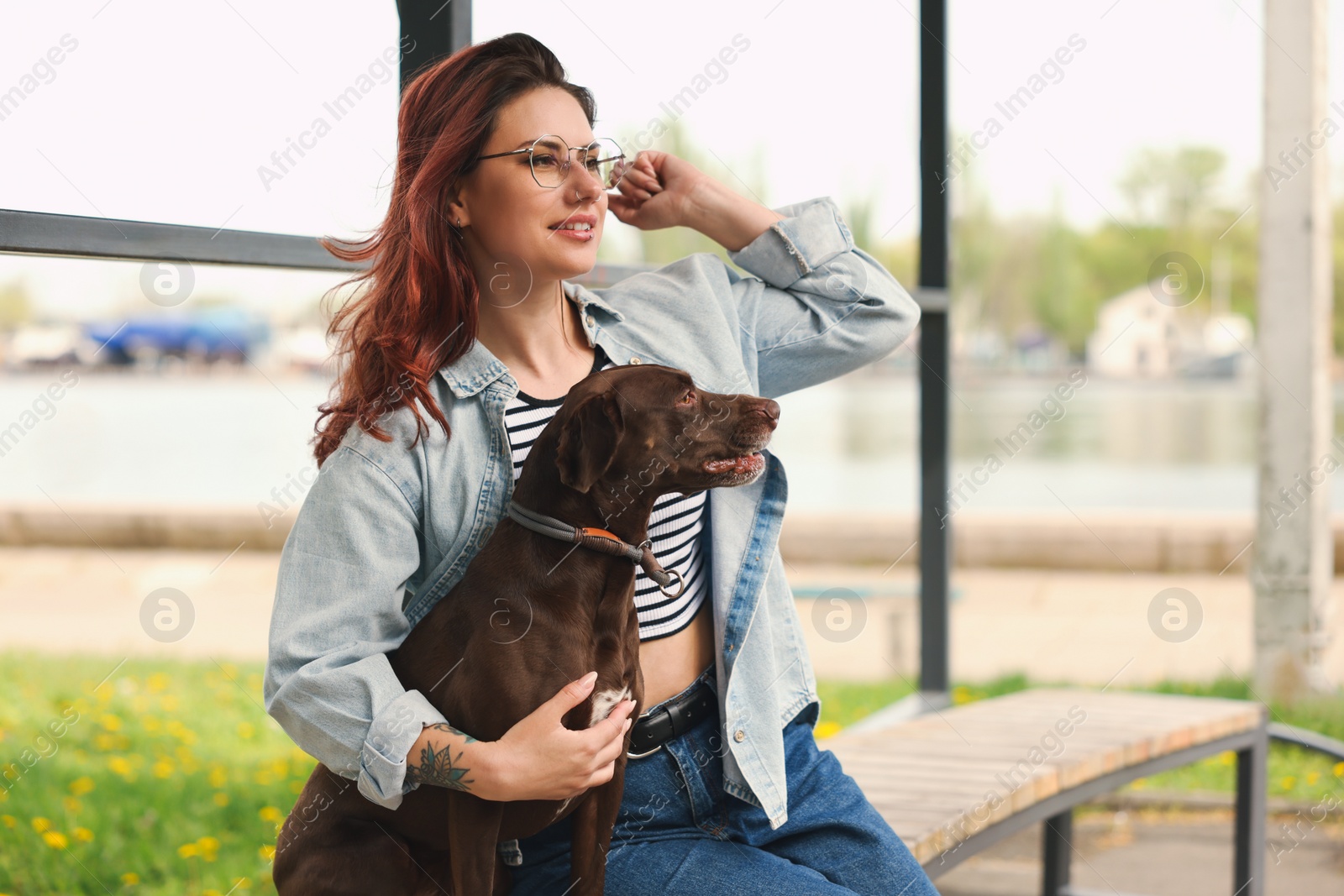 Photo of Woman with her cute German Shorthaired Pointer dog outdoors