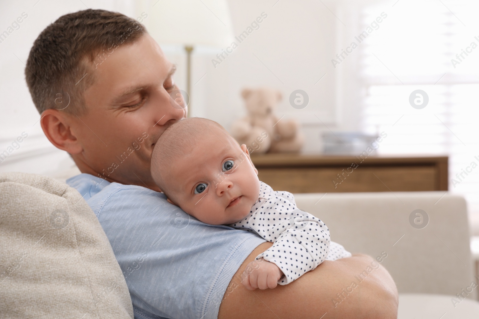 Photo of Happy father holding his cute little baby at home, space for text