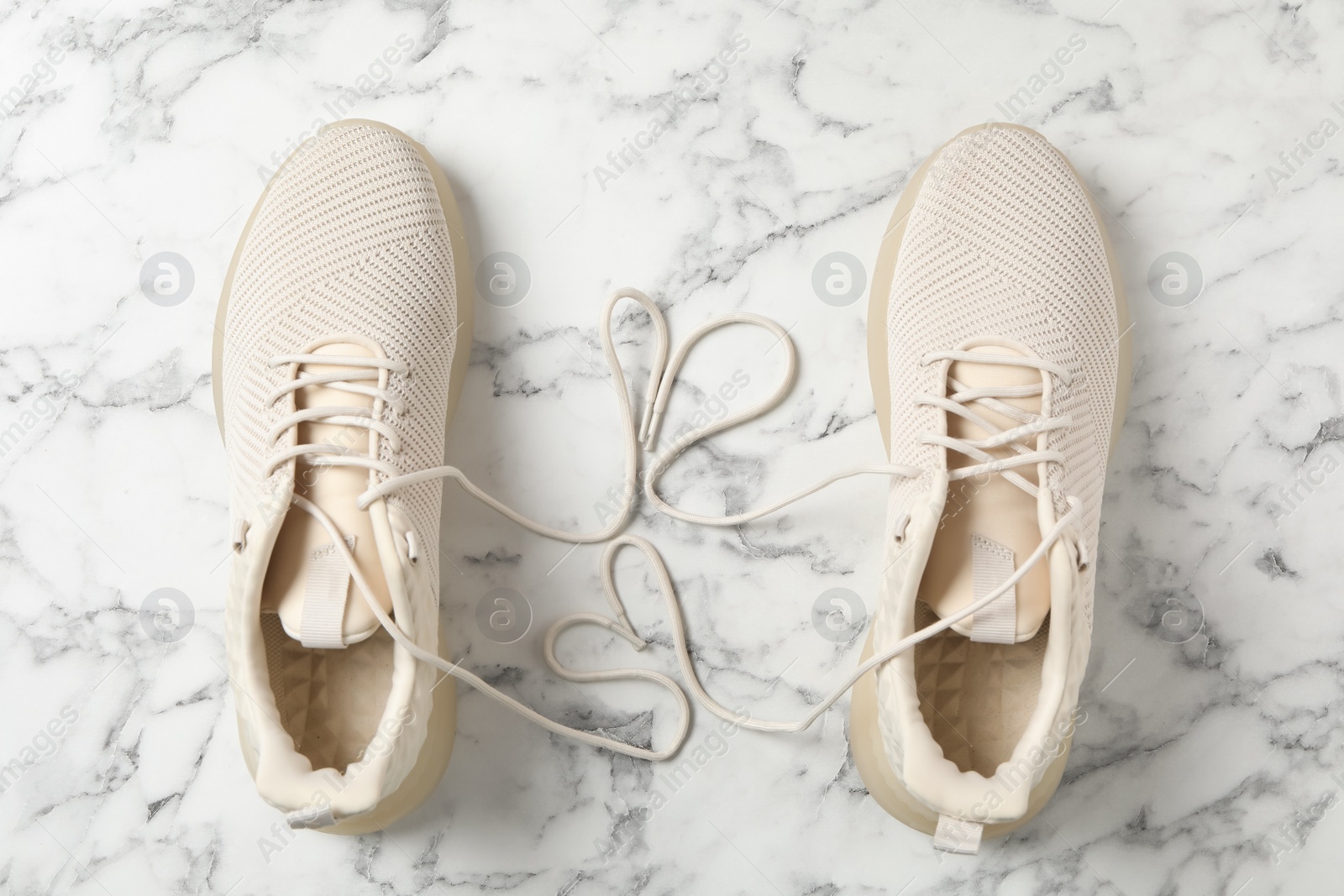 Photo of Pair of stylish shoes with laces on white marble background, flat lay