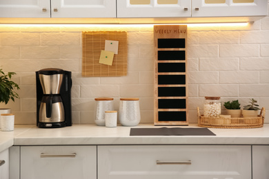 Photo of Stylish kitchen interior with modern coffeemaker on countertop