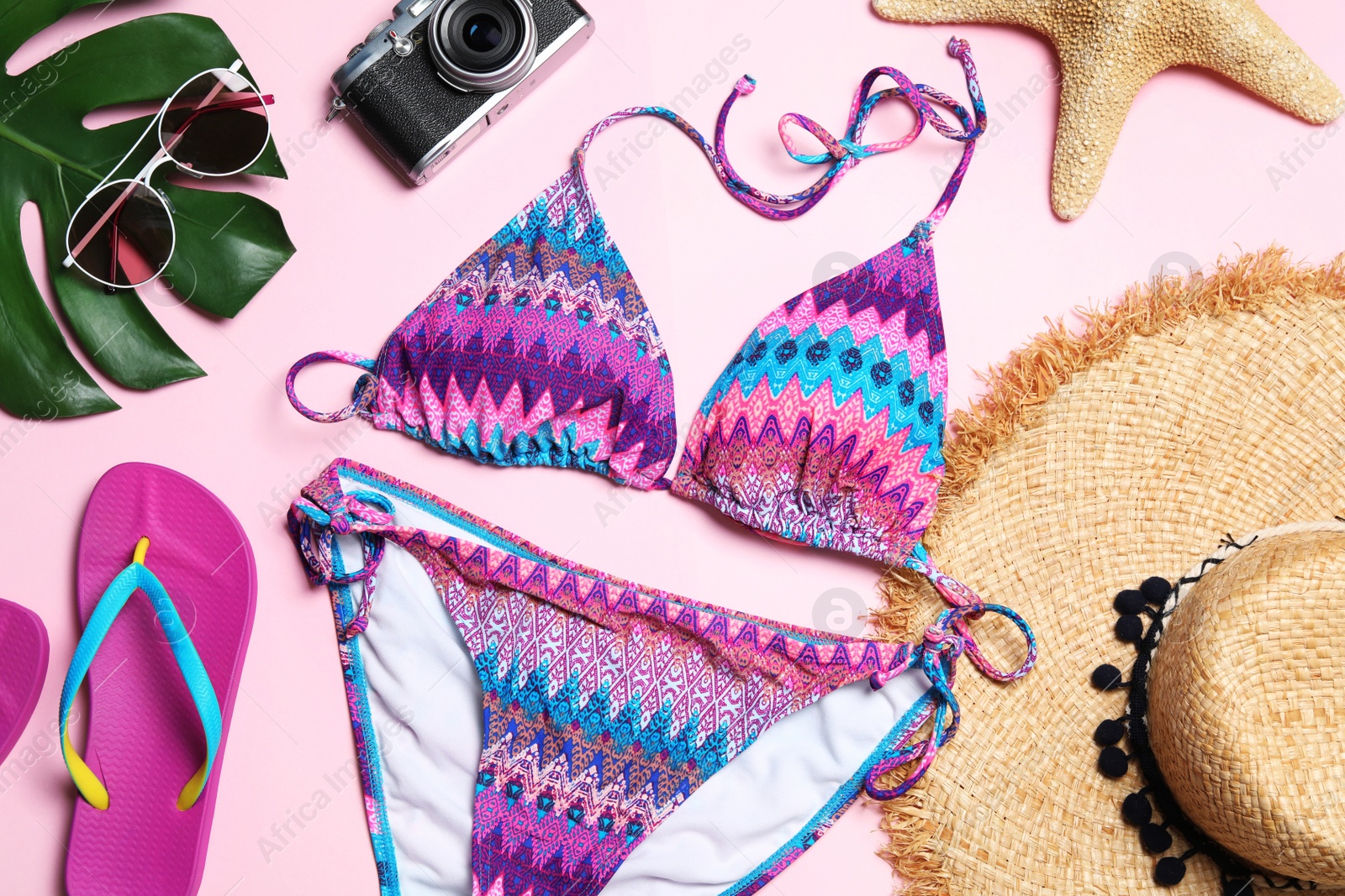 Photo of Flat lay composition with stylish bikini on color background. Beach objects