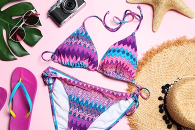 Flat lay composition with stylish bikini on color background. Beach objects