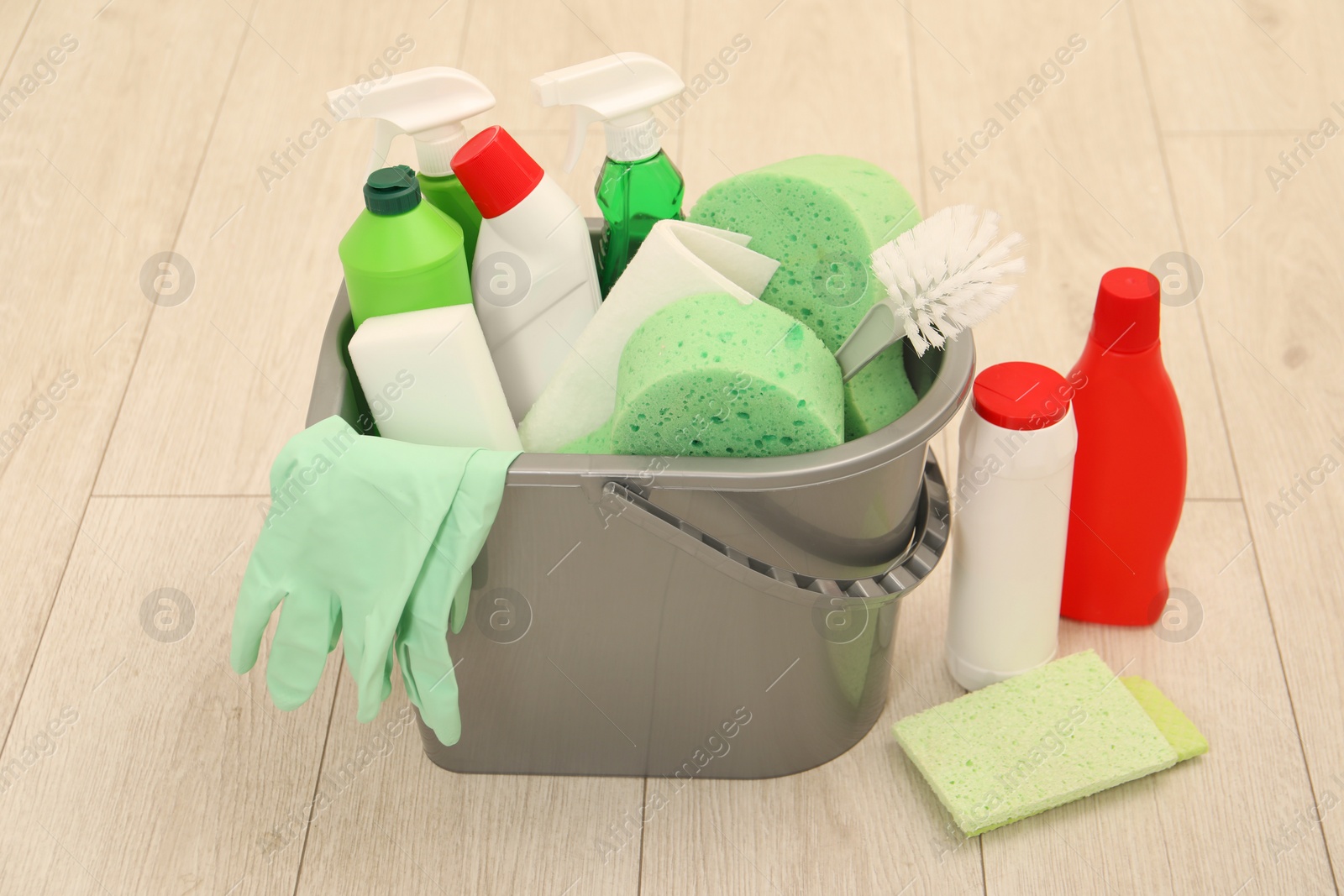 Photo of Different cleaning supplies in bucket on floor