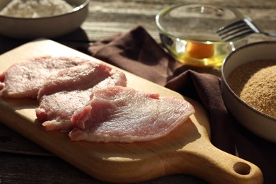 Photo of Cooking schnitzel. Raw pork slices and other ingredients on table, closeup