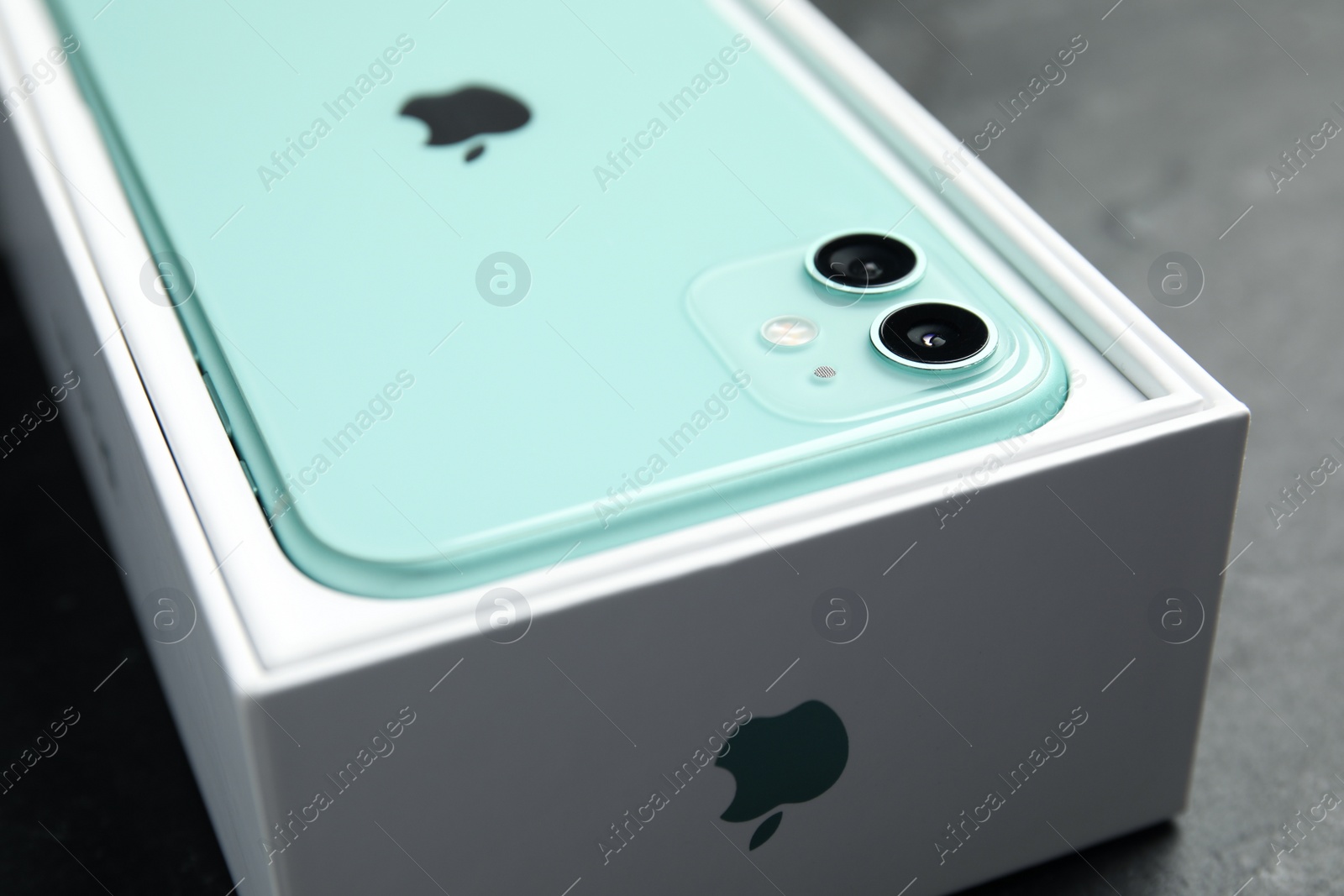 Photo of MYKOLAIV, UKRAINE - JULY 10, 2020: New modern Iphone 11 Green in original box on grey table, closeup