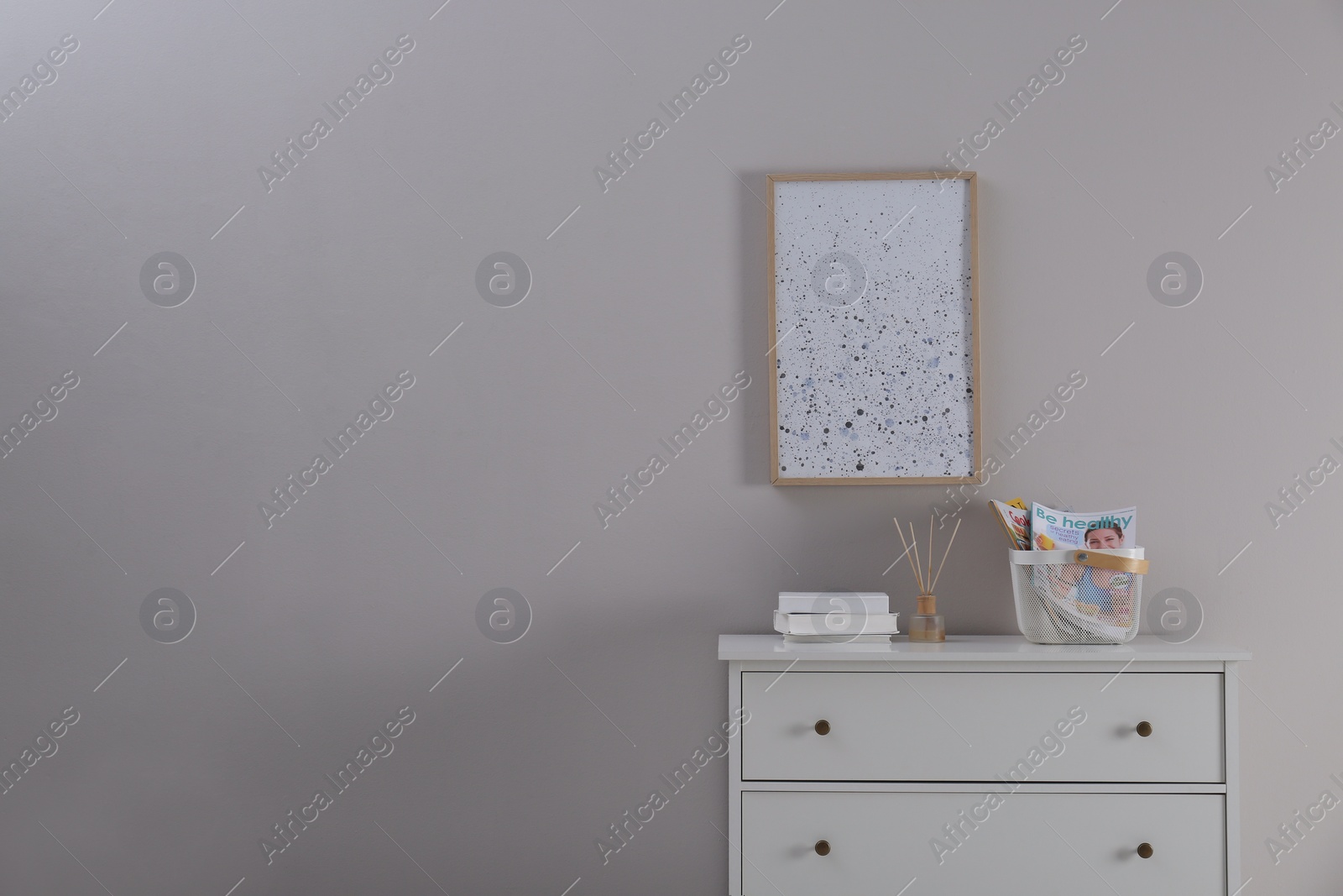 Photo of White chest of drawers and decor in room, space for text. Interior design