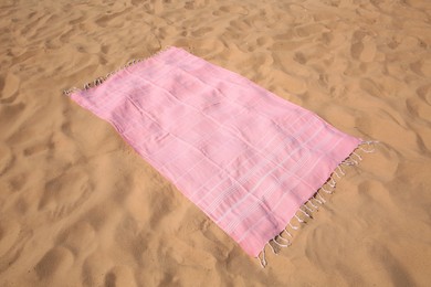 Photo of Beautiful pink striped beach towel on sand